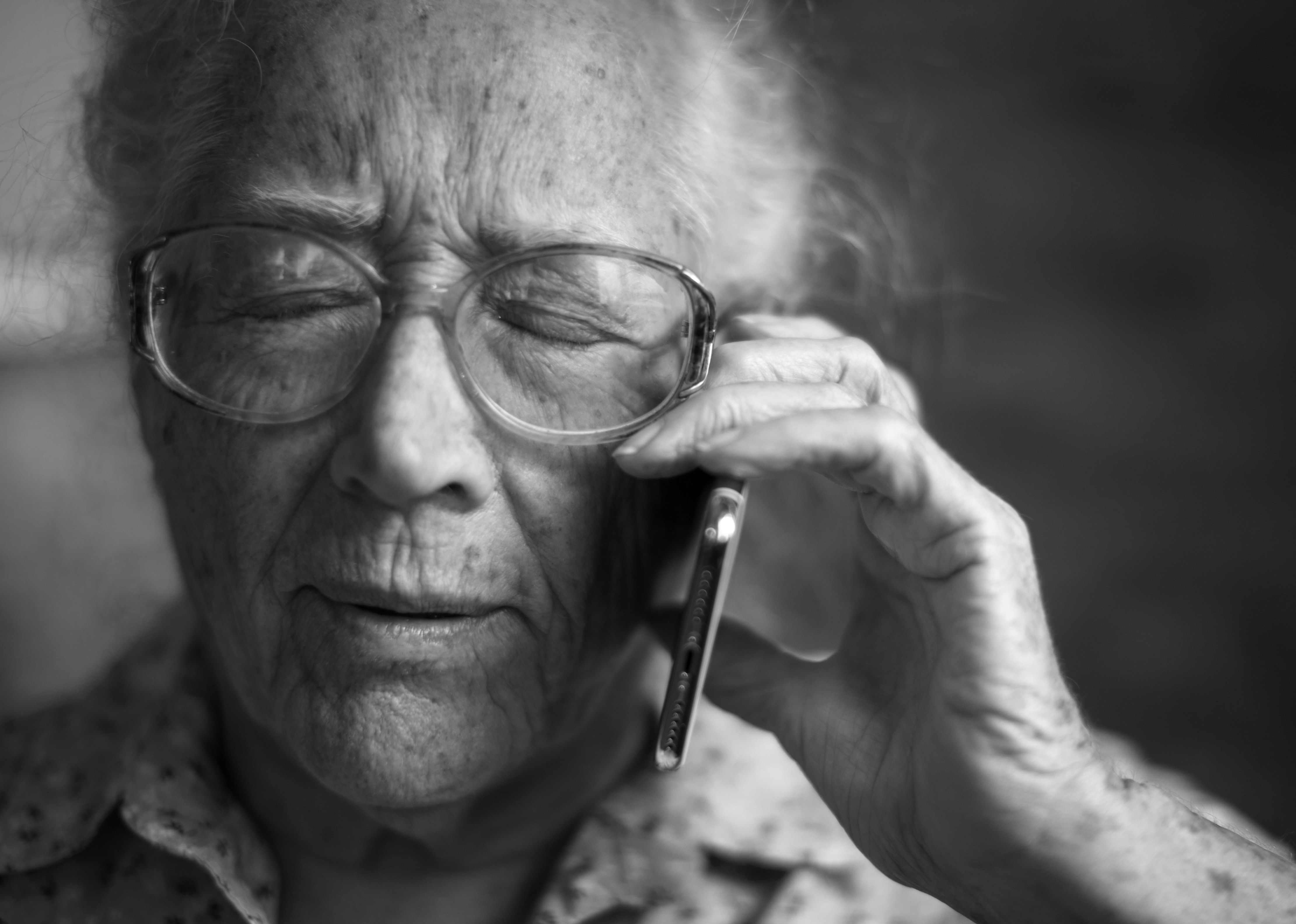 Older woman in black and white holding mobile phone